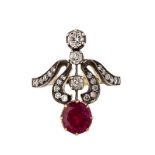 A Belle Epoque ruby and diamond set ring of scrolling design, claw set with a round cut ruby and