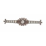 A diamond and pearl set broochclaw set with a rose cut diamond in a radiating border of smaller