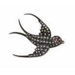 A diamond set swallow broochset throughout with small rose cut diamonds and a cabochon ruby eye,