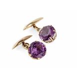 A pair of Alexandrite set cufflinkseach set with a single round cut alexandrite in a unmarked yellow