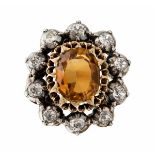 A citrine and diamond set ringclaw set with an oval cut citrine, in a single border of old cut