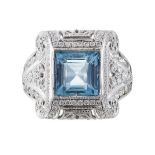 An aquamarine and diamond set dress ringthe square cut aquamarine in a white metal surround, with