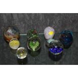 An assortment of nine glass paper weights