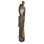 A Papuan New Guinea guardian figure female with spirit bird on shoulder in carved wood, on a