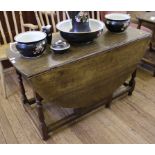 A 19th century oak gate leg action table with twin drop leaves, raised on turned legs and