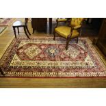 A red ground Aztec-design drawing room rug, 240cm x 160cm