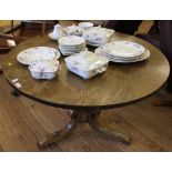 A 19th century oak circular centre table on a turned central column with 'C' scroll-shaped tripod