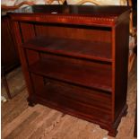 A 19th century-style mahogany freestanding bookcase with dentil frieze, adjustable shelving,