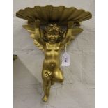 A pair of 19th century parcel gilt wall brackets in the form of cherubs holding a shell