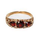 A 9 carat gold ring set with garnets and diamonds