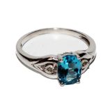 A 9 carat white gold ring set with blue stone, possibly topaz flanked by two diamonds