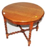 An early 20th century light oak circular occasional table with shaped top, rope twist supports