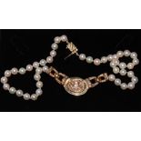 A cultured pearl necklace with diamond set centre piece