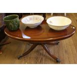 A 19th century-style elliptical mahogany coffee table with shaped top, inlay and turned central