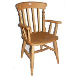 A hardwood country kitchen chair with shaped top rail, spindle supports, carved arm rests, raised on