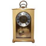 A brass mantle clock with circular dial, Roman numerals, 18cm x 13cm