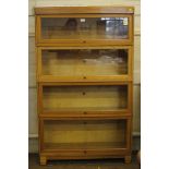 A 1920s Globe Wernicke Limited light oak bookcase with four up and over glazed doors, with