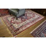 A red ground Aztec-design drawing room rug, 240cm x 160cm