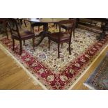 A Kashmir-style ivory ground multicoloured floral and foliate-design floor rug with double border