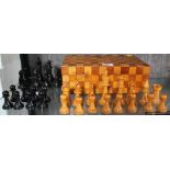 An early 20th century chess set with checkered mahogany and satinwood oblong box