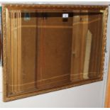 An oblong bevelled edged wall mirror with profusely carved gilt frame, 56cm x 62cm