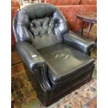 A mahogany framed green leather upholstered easy chair with button back support, shaped arm rests