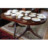 A Regency-style 'D' end mahogany dining table with string inlay to the shaped top, raised on twin