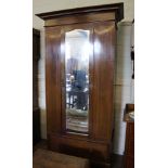 An Edwardian mahogany and cross banded single wardrobe with shaped cornice, central mirrored door,
