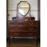 An Edwardian mahogany and cross banded dressing table with shield-shaped bevelled mirror, two