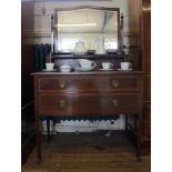 An Edwardian mahogany and cross banded dressing table with oblong bevelled mirror on finial topped