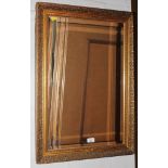 An oblong bevelled glass wall mirror with profusely carved gilt frame, 77cm x 54cm