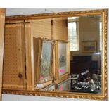 An oval bevelled wall mirror with profusely gilt frame, 48H x 75cmW