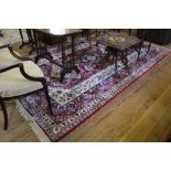 An Aztec-style red-ground drawing room rug with treble border, isometric multicoloured designs