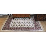 A Middle Eastern-style ivory ground drawing room rug with multicoloured isometric and lozenge-