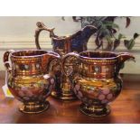 A pair of mid 20th century lustre jugs with floral and foliate multicoloured depictions and a larger