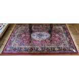 A Middle Eastern-style red ground drawing room carpet with multicoloured floral and foliate