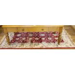 An Oriental red-ground rug of oblong form with ivory border with floral and foliate designs with