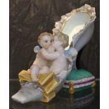 A late 19th century Dresden figurine of a lady's shoe with two embracing cherubs to the front on a