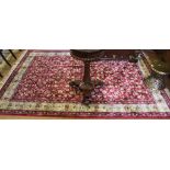 A Middle Eastern-style red ground drawing room rug with ivory border with multicoloured floral and