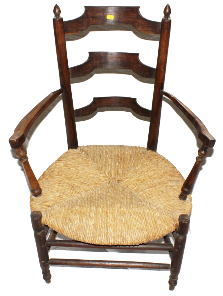 An Arts and Crafts oak and elm Sussex chair with ladder back support with finials to the uprights,