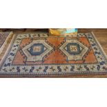 A Turkish hand knotted wool pile rug with multicoloured isometric designs with short fringe, 220cm x