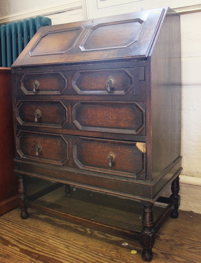 An early 20th century oak stained bureau with fold down front, fitted interior with three graduating