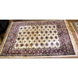 A Middle Eastern-style ivory-ground drawing room rug with multicoloured isometric and lozenge-