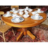 A Victorian-style light oak circular dining table, moulded top with fold away extra leaf, raised