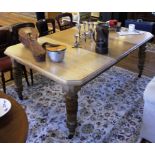 A Victorian mahogany extending dining table with moulded top, canted corners, raised on turned