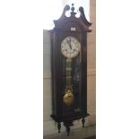 A 19th century style mahogany Viennese wall clock with circular dial, Roman numerals and carved