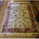 An ivory ground Kashmir-style red-ground floor rug with multicoloured floral design with long