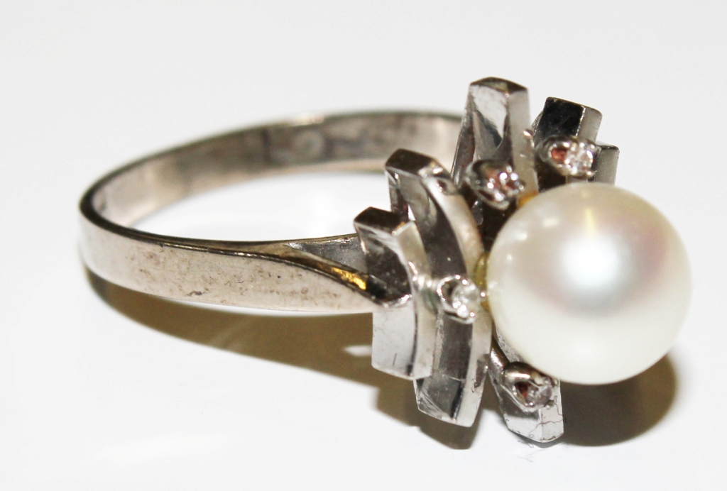 A pearl and diamond cluster ring set in white colour metal