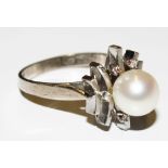 A pearl and diamond cluster ring set in white colour metal
