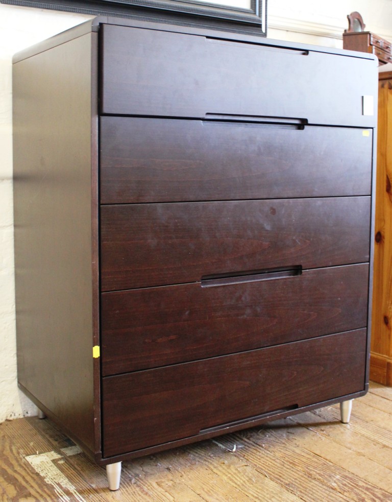 A contemporary oak stained veneered chest of five drawers with shaped top on conical aluminium legs,